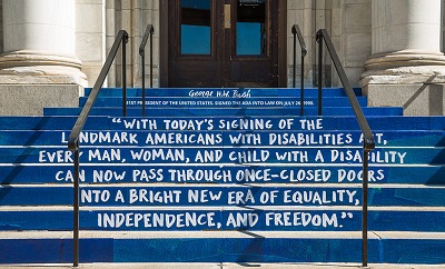 President George H. W. Bush signs the Americans with Disabilities Act (ADA) into law. With today's signing of the landmark Americans with Disabilities Act, every man, woman, and child with a disability can now pass through once-closed doors into a bright new era of equality, independence, and freedom.