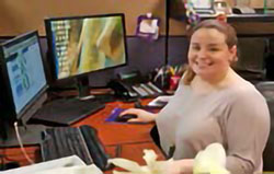 Ingrid Cuperio sitting at her desk as a member of the programming department at Telemundo Network