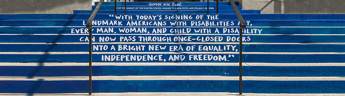 Image of stairs with the following quote written on them: George H.W. Bush, 41st President of the United States signed the ADA into law on July 26, 1990. With Today's signing of the landmark Americans with Disabilities Act, every man, woman, and child with a disability can now pass through once-closed doors into a bright new era of equality, independence, and freedom.